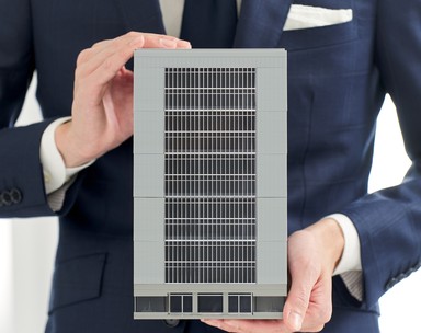 ビルの模型を持つビジネスパーソン